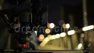 视频dslr相机前进在滑块与灯和栅栏的背景。 幕后视频制作